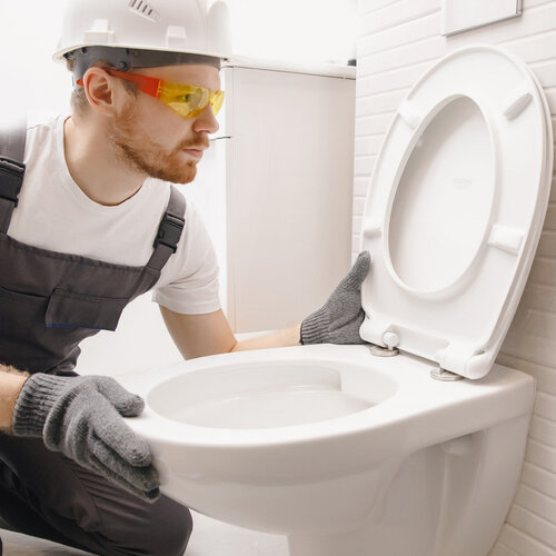 plumber installing a toilet bowl