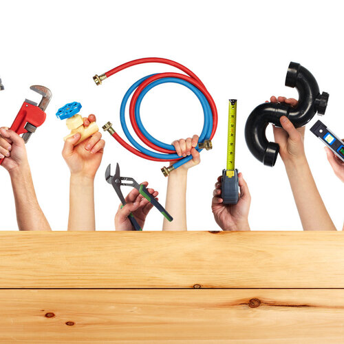 hands holding various HVAC and plumbing tools and equipment