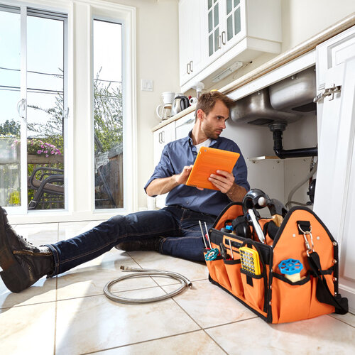 plumber working beneath a kitchen sink