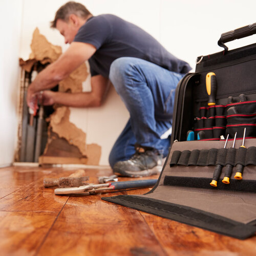 plumber providing emergency plumbing repair for a burst pipe