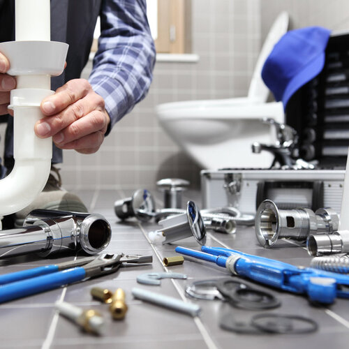 plumber providing toilet repair in a home bathroom